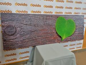 Obraz liść w kształcie serca na drewnianym tle
