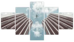 Obraz samolotu między budynkami (125x70 cm)
