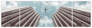 Obraz samolotu między budynkami (170x50 cm)