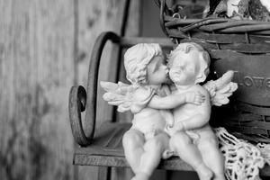 Obraz figurki aniołów na ławce w wersji czarno-białej