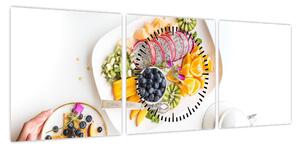 Obraz talerzy z owocami na stole (z zegarem) (90x30 cm)