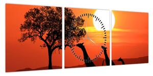 Obraz żyraf o zachodzie słońca (z zegarem) (90x30 cm)