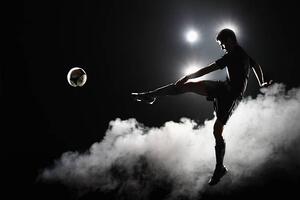 Fotografia Soccer player kicking the ball at night on stadium, Stanislaw Pytel